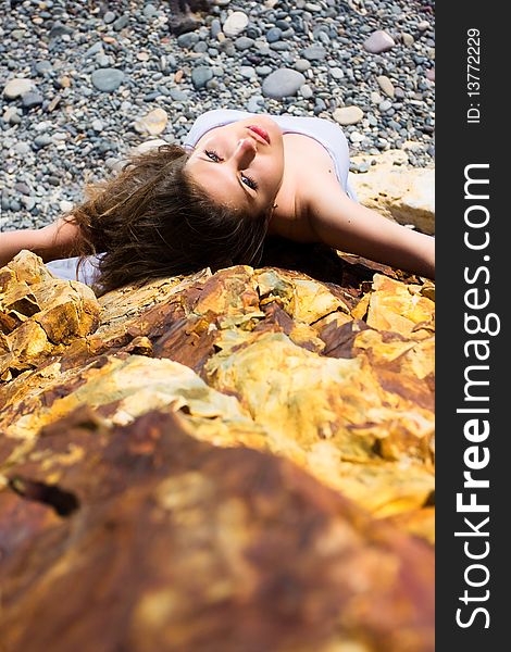 Woman in white dress from material and rocks