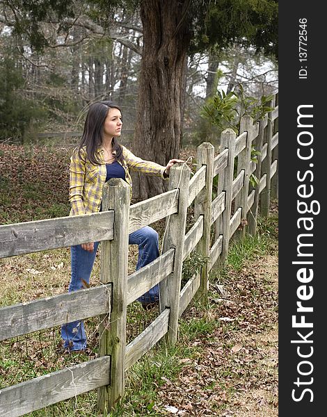 Young woman propped on old wooden pasture fence. Young woman propped on old wooden pasture fence