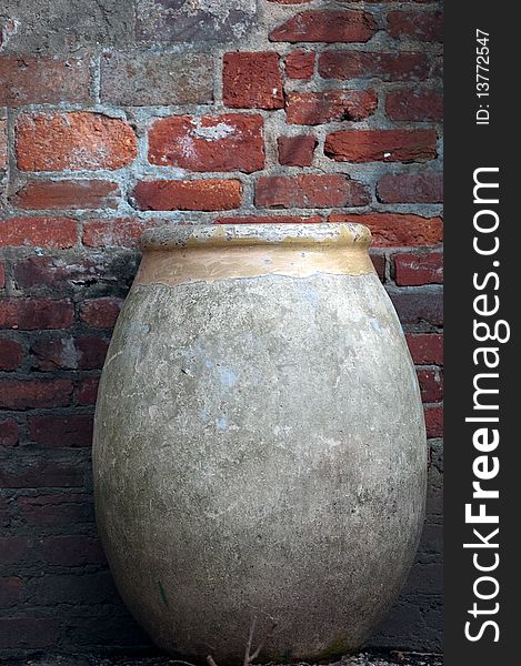Clay urn against red brick wall. Clay urn against red brick wall