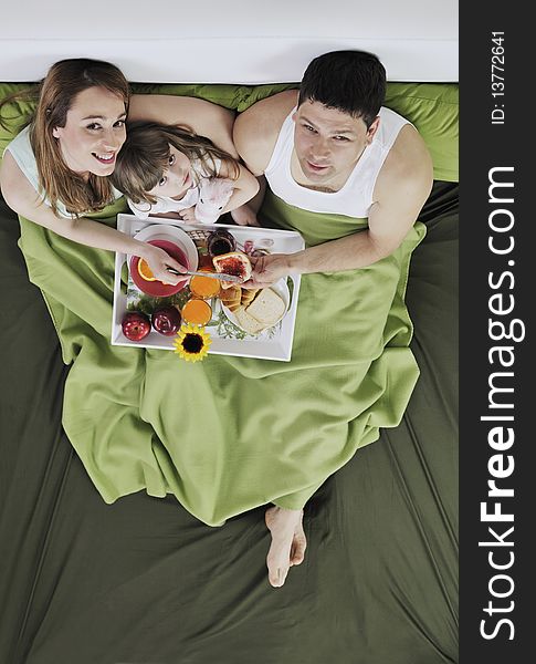 Happy Young Family Eat Breakfast In Bed