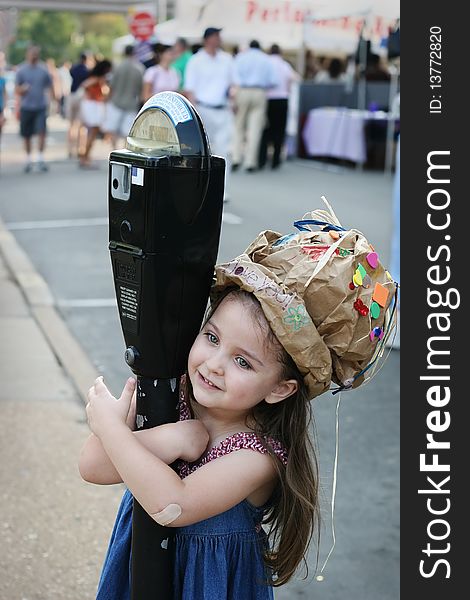 Portrait of a cute girl in the craft hat she made at a local art fair. Portrait of a cute girl in the craft hat she made at a local art fair.