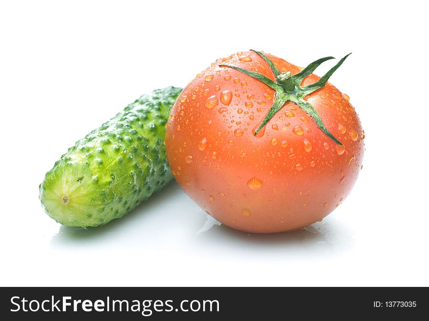 Red tomato and green cucumber with water drops isolated on white
