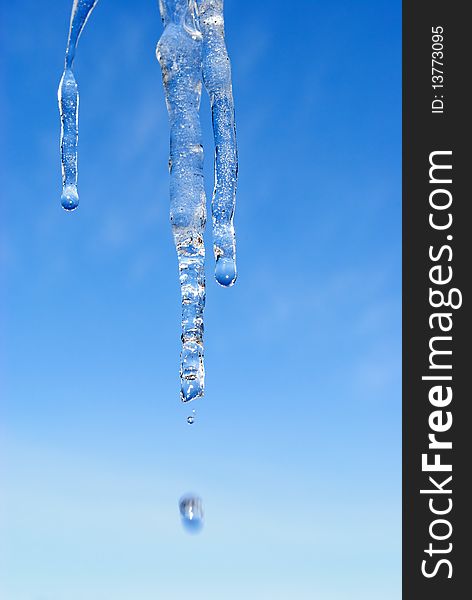 Thawing of an icicle against the evening sky, in the beginning of spring. Thawing of an icicle against the evening sky, in the beginning of spring