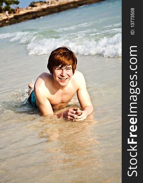 Happy boy with red hair at the beach