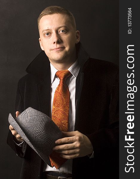 Young, elegant businessman, calm and confident face expression. Wearing shirt, tie and black coat, holding hat. Young, elegant businessman, calm and confident face expression. Wearing shirt, tie and black coat, holding hat.