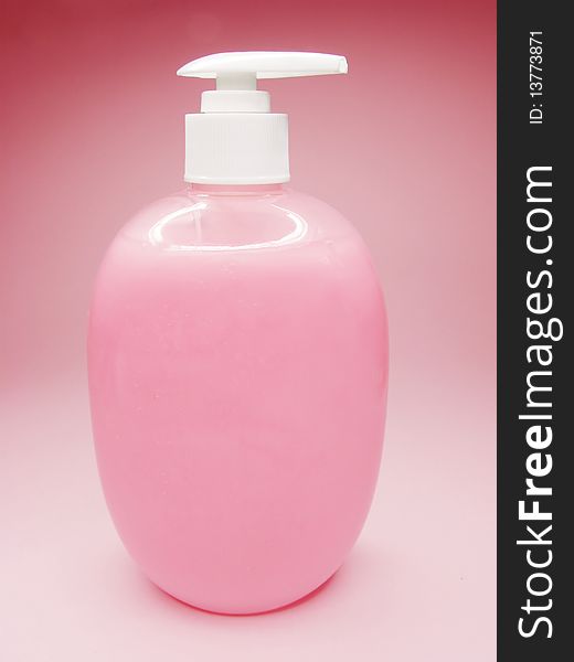 Liquid soap with rose extract on colored background