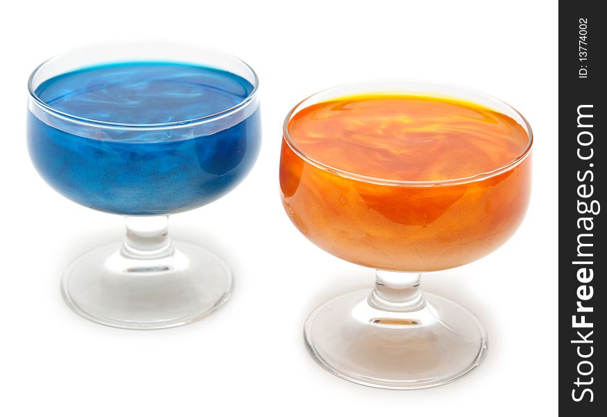 Orange and blue glasses with mother-of-pearl jelly on white background