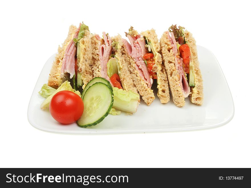 Wholemeal ham salad sandwich with garnish on a plate