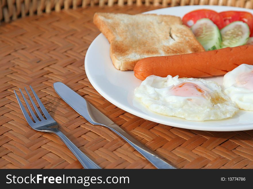 Delicious breakfast with bread sausage fried egg Cucumber and tomatoes