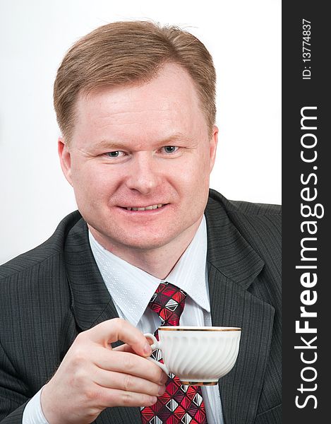 Portrait of the man in a new grey suit with a coffee cup in hands. Portrait of the man in a new grey suit with a coffee cup in hands.
