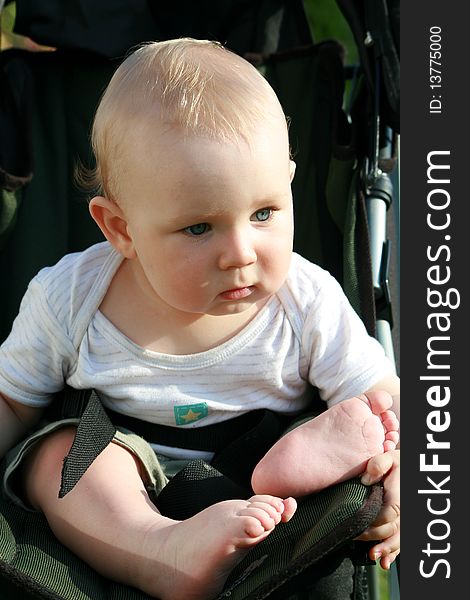 Seven months old baby boy sitting in a baby stroller. Seven months old baby boy sitting in a baby stroller.