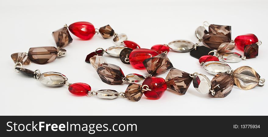 Beads of red and beige glass on a white background. Beads of red and beige glass on a white background