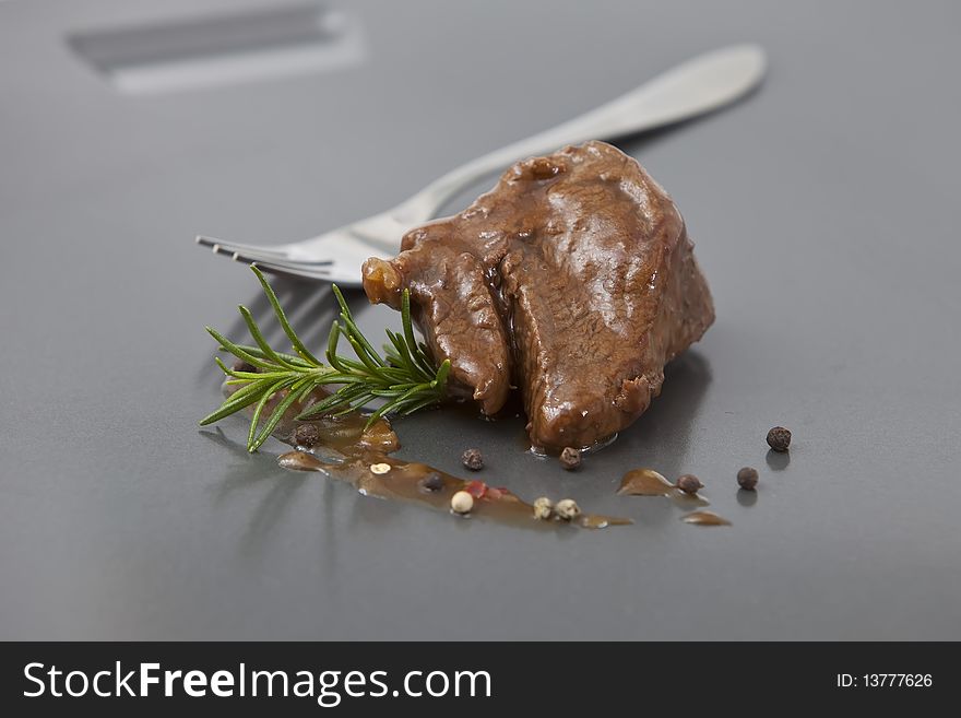 Beef tenderloin with onion sauce on grey tray