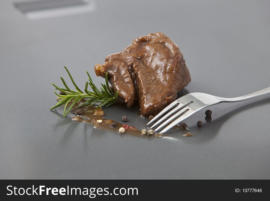 Beef tenderloin with onion sauce on grey tray