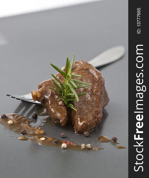 Beef tenderloin with onion sauce on grey tray