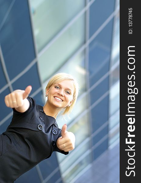 Businesswoman successfully holds thumbs up. Image taken on a modern abstract background. Businesswoman successfully holds thumbs up. Image taken on a modern abstract background.