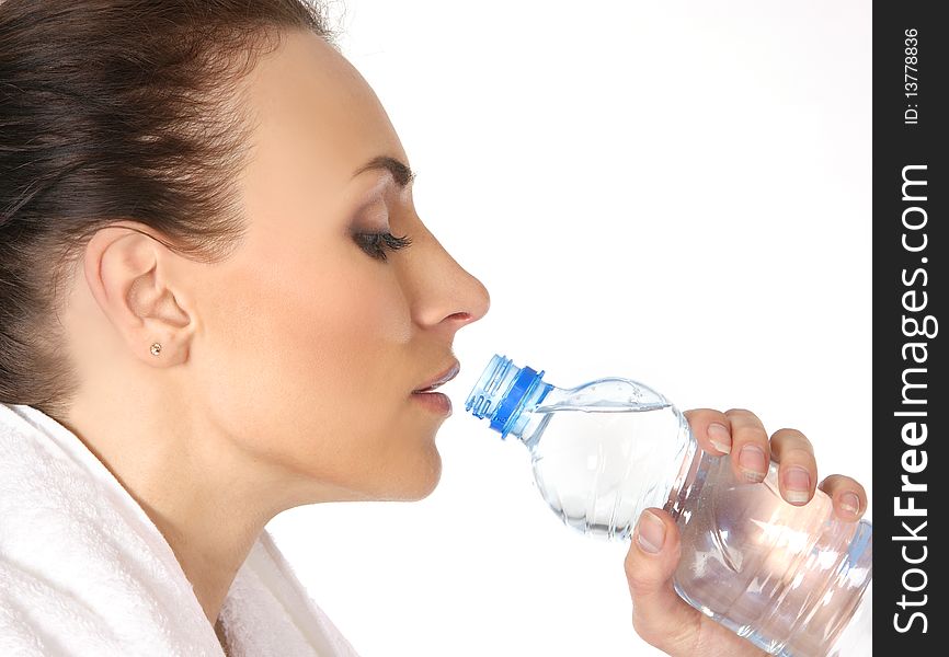 Young and attractive female sportsman drinking water after training. Image isolated on white background.