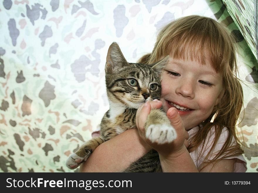 Small girl embraces by hands kitten. Small girl embraces by hands kitten