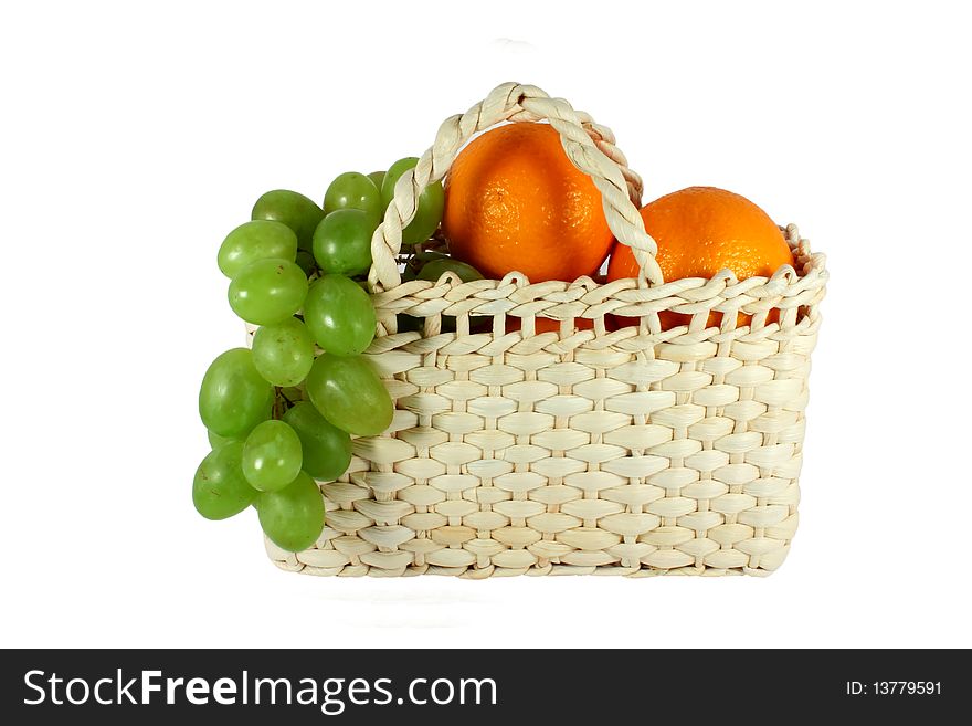 Little basket full of grapes and oranges isolated on white