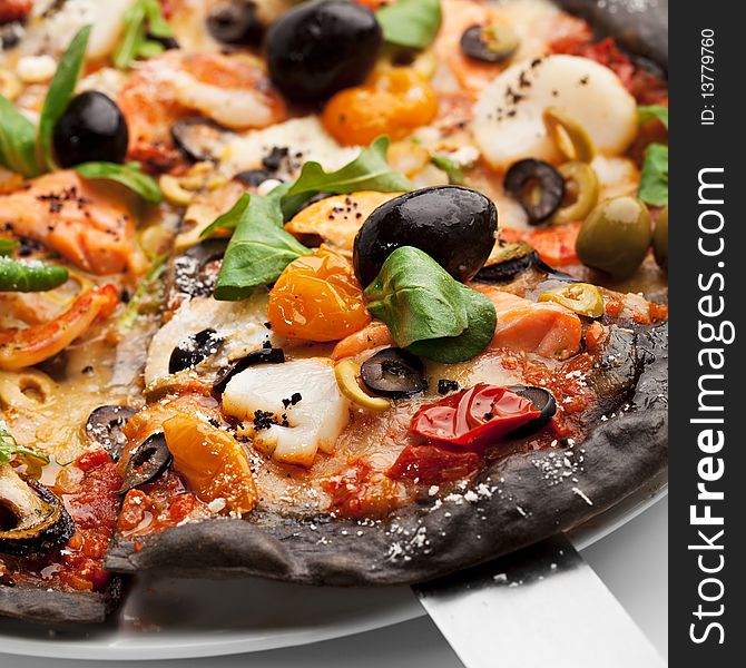 Black Ink Dough Pizza with Seafood, Black and Green Olives, Dried Tomato and Salad Leaves. Black Ink Dough Pizza with Seafood, Black and Green Olives, Dried Tomato and Salad Leaves