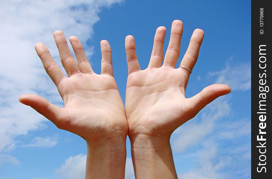A hands begging alms on a sky background