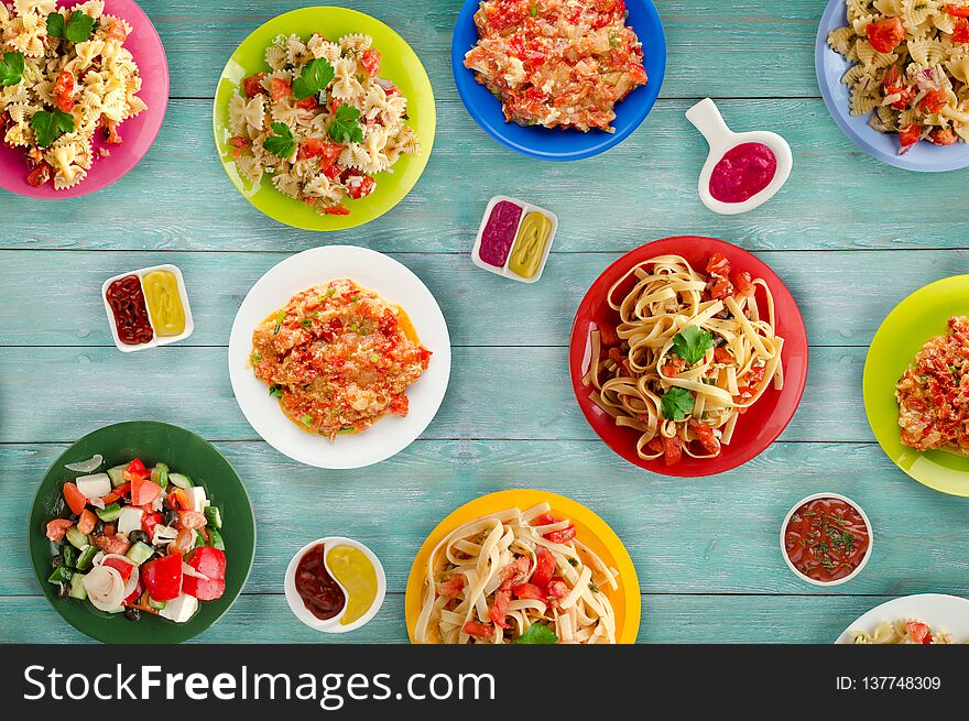 Pasta with vegetables and sauce on a table. Spaghetti on a plate. Mediterranean food