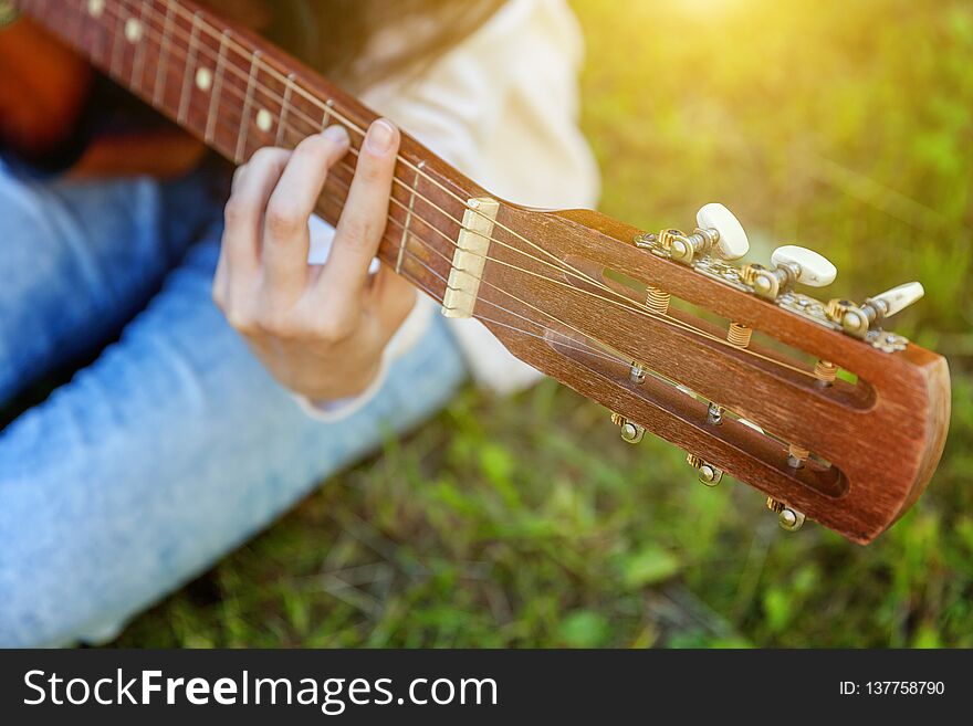 Woman hands playing acoustic guitar