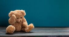 Teddy Bear Sad, Sitting On The Wooden Floor, Blue Empty Room Background, Copy Space Stock Image
