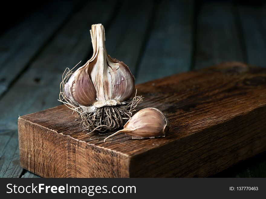 Raw garlic on wooden background, rustic style.