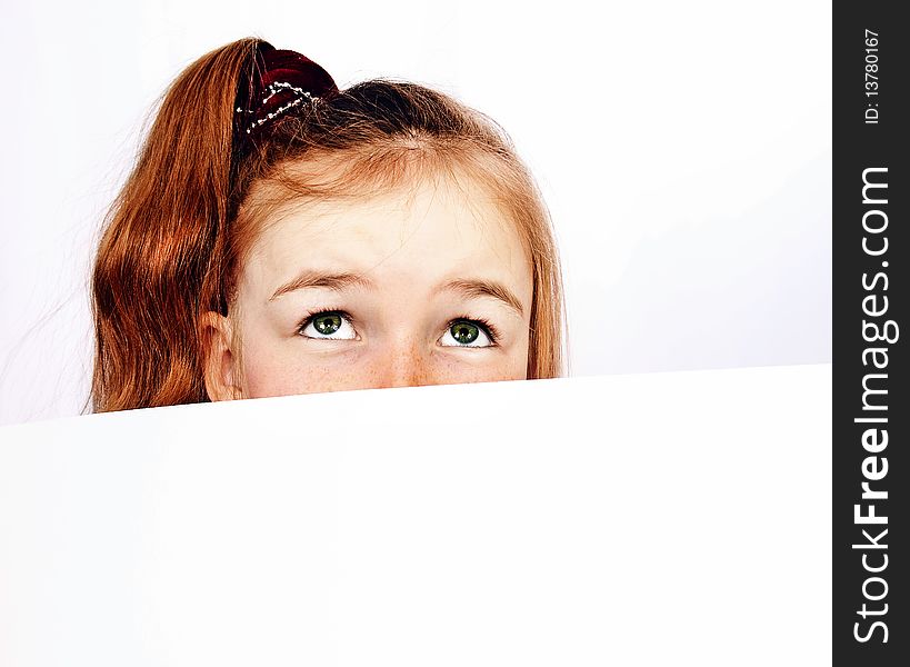 Redhead girl peeping out of paper. Redhead girl peeping out of paper