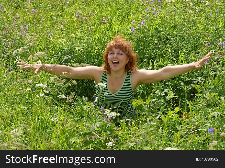 Beauty middle aged woman sits on meadow. Beauty middle aged woman sits on meadow