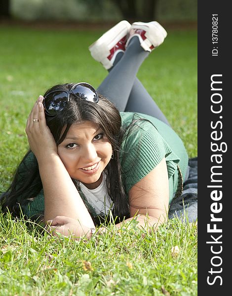 Portrait of beauty young woman lying on grass at park