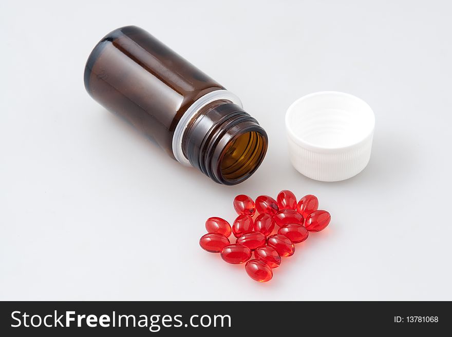 Little vial and lot of red tablets. Little vial and lot of red tablets