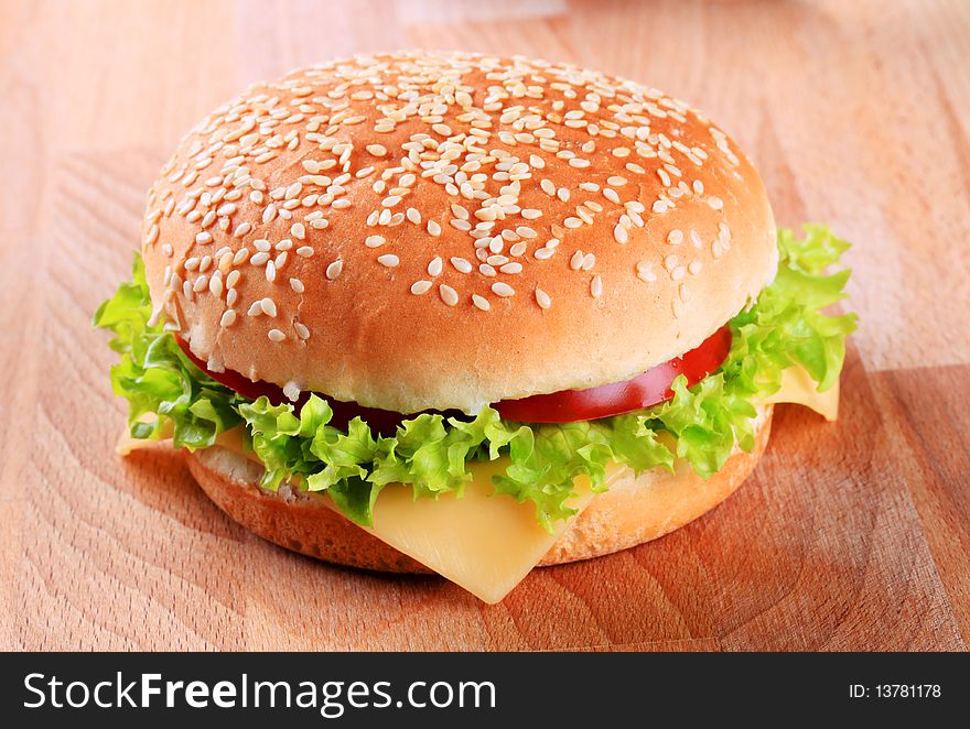 Sesame seed bun with lettuce, tomato and cheese. Sesame seed bun with lettuce, tomato and cheese
