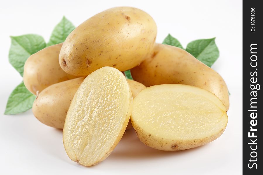 Yellow potatoes with leaves on a white background