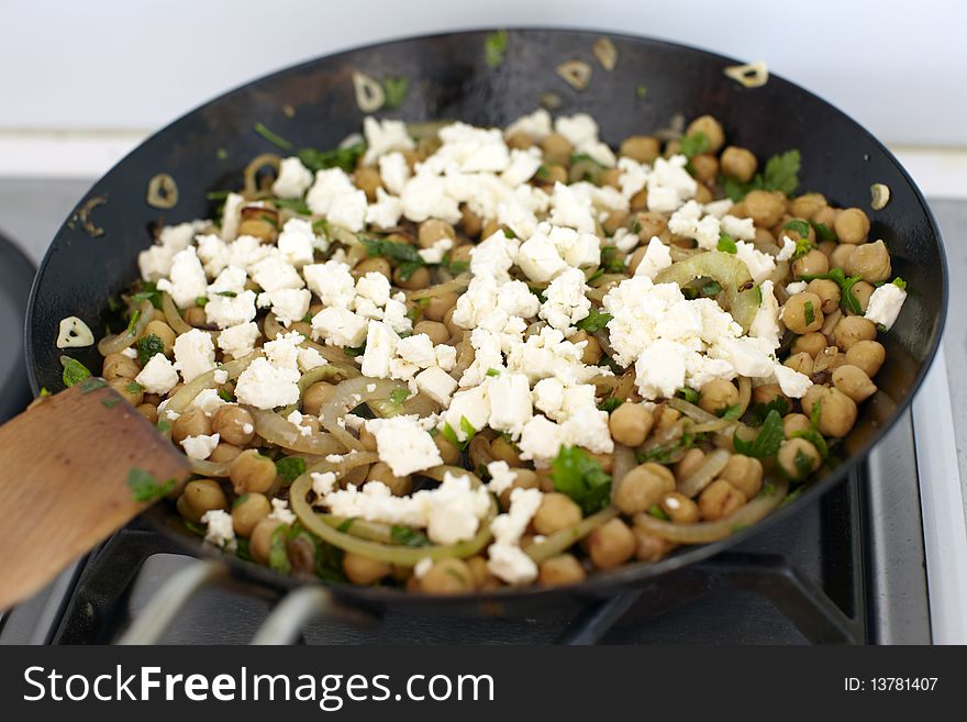 Chickpeas and feta cheese in a cast iron pan