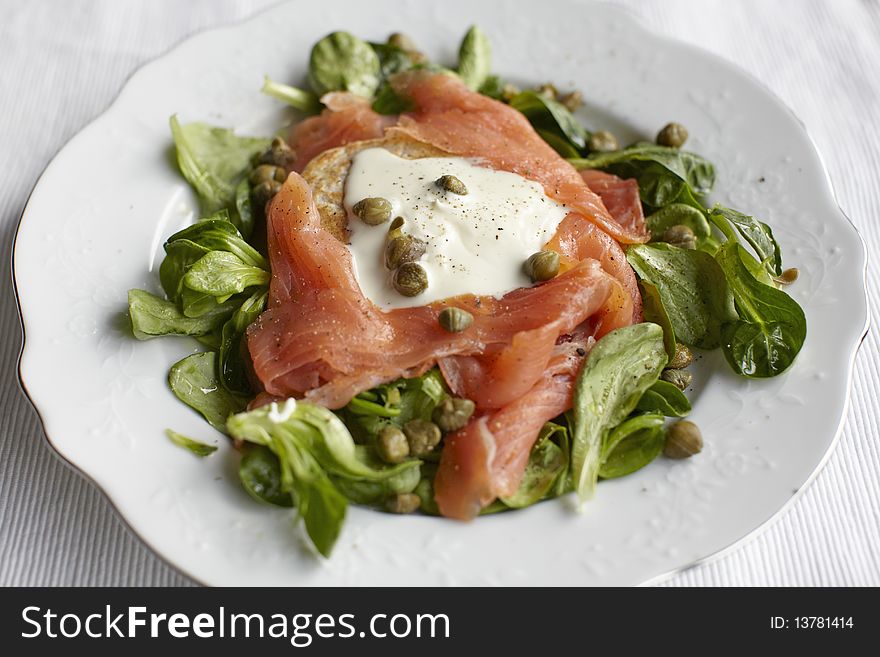 Smoked salmon salad with blinis and capers