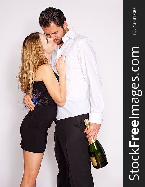 Romantic young couple with champagne bottle and glasses, white background. Romantic young couple with champagne bottle and glasses, white background