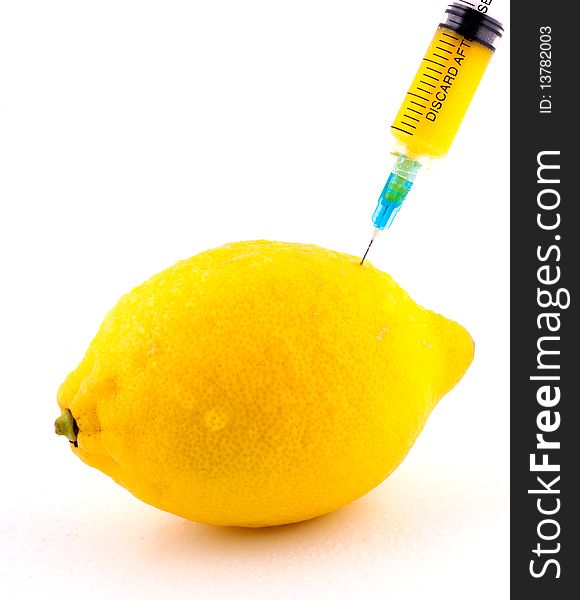 Lemon With Syringe Injecting Color on Isolated White Background