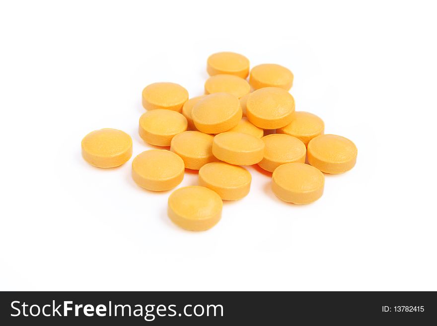 Pile of orange pills isolated on white background