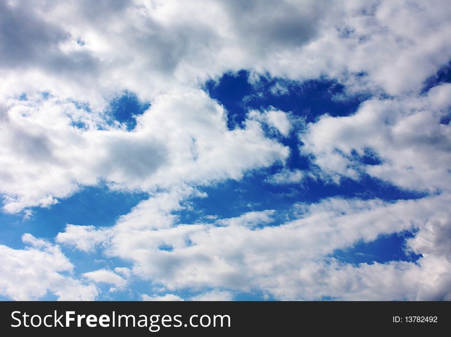 Deep blue sky with white and gray clouds background