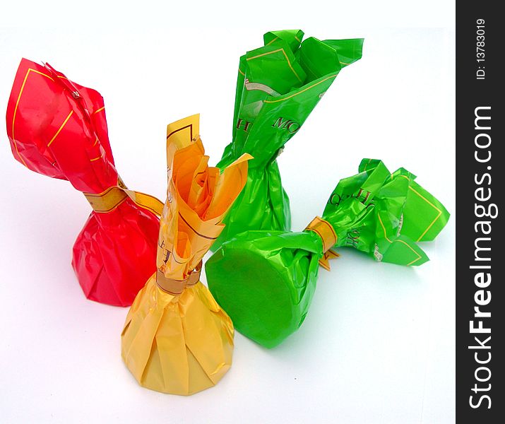 Chocolates in bright wrappers are on the image. Chocolates in bright wrappers are on the image