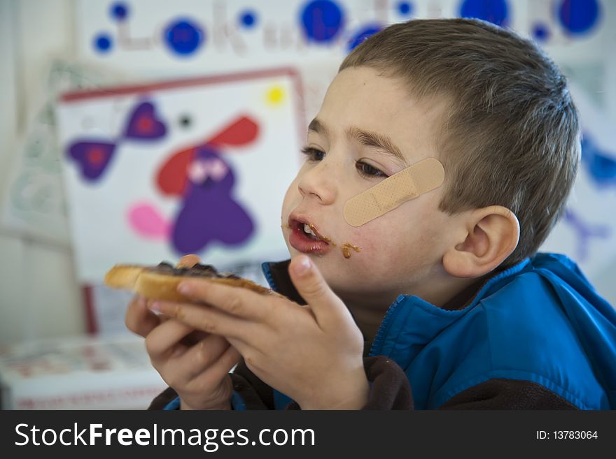 Young Boy Eating A Sandwich.