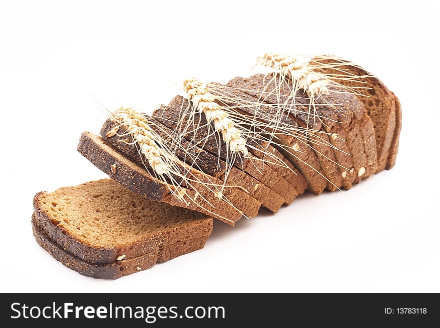 The cut bread on a white background with wheat