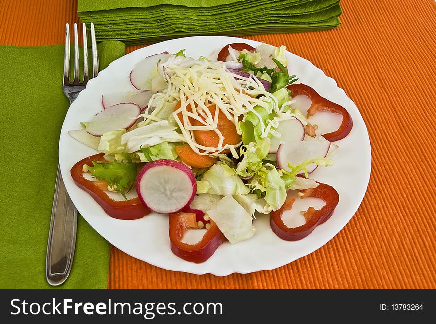 Orange and green table setting, light organic salad