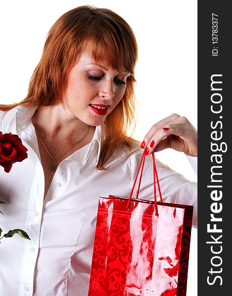 Portrait of a beautiful redhead girl with a gift and a rose