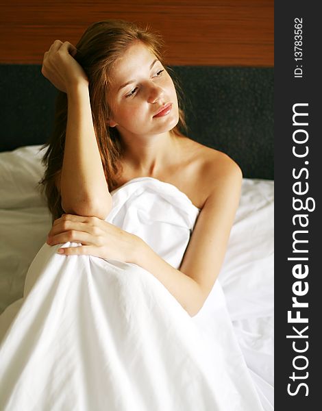 Young beautiful woman sitting in her bed. Young beautiful woman sitting in her bed