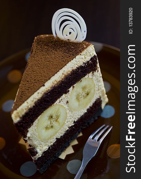 Banana cake on the brown plate with fork.