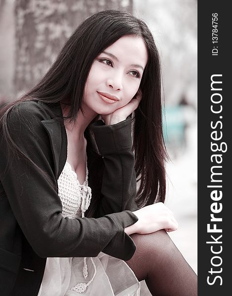 Young Asian woman with long hair sitting and enjoying the scenery in spring. Young Asian woman with long hair sitting and enjoying the scenery in spring.