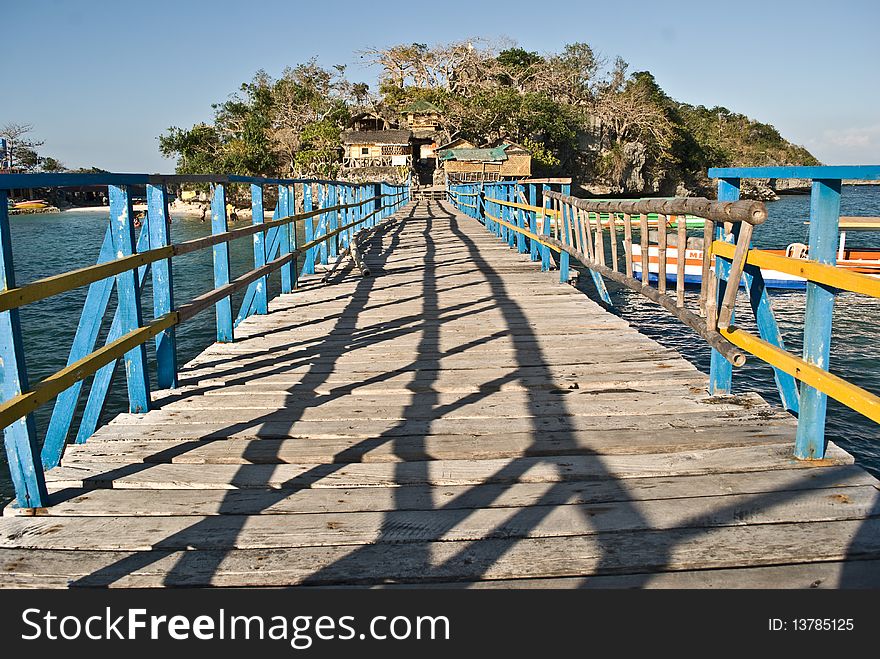 A wooden bridge connects two small islands which are part of the Hundred Islands in the Philippines. A wooden bridge connects two small islands which are part of the Hundred Islands in the Philippines.